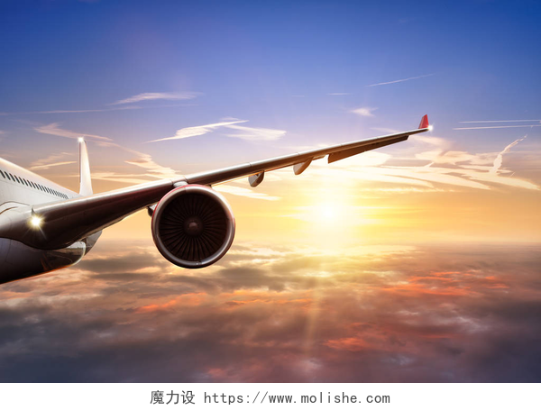 美丽夕阳云层上飞行的商用喷气式飞机机翼前视图夕阳在云层上面飞行的飞机的翅膀